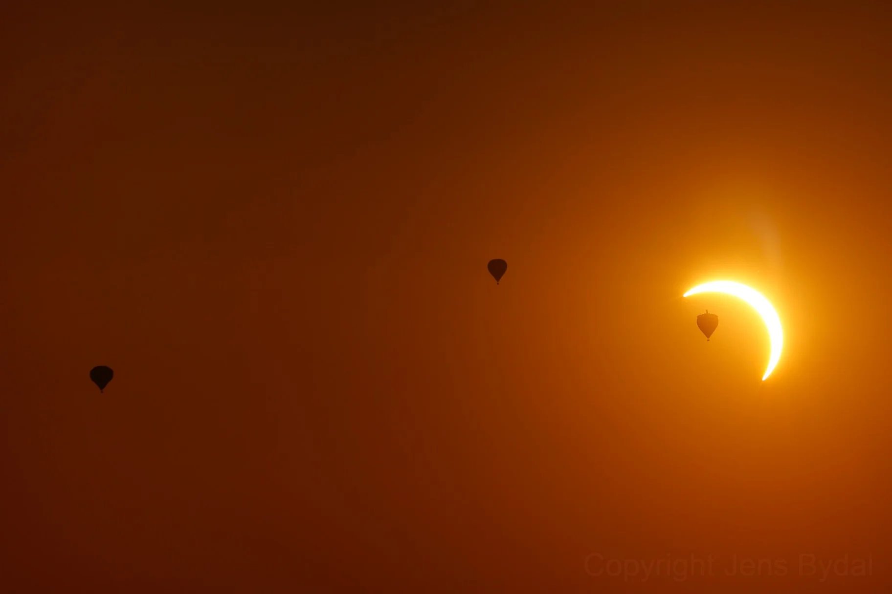 Balloons float past a partially eclipsed Sun. Credit: Mr. Photon.