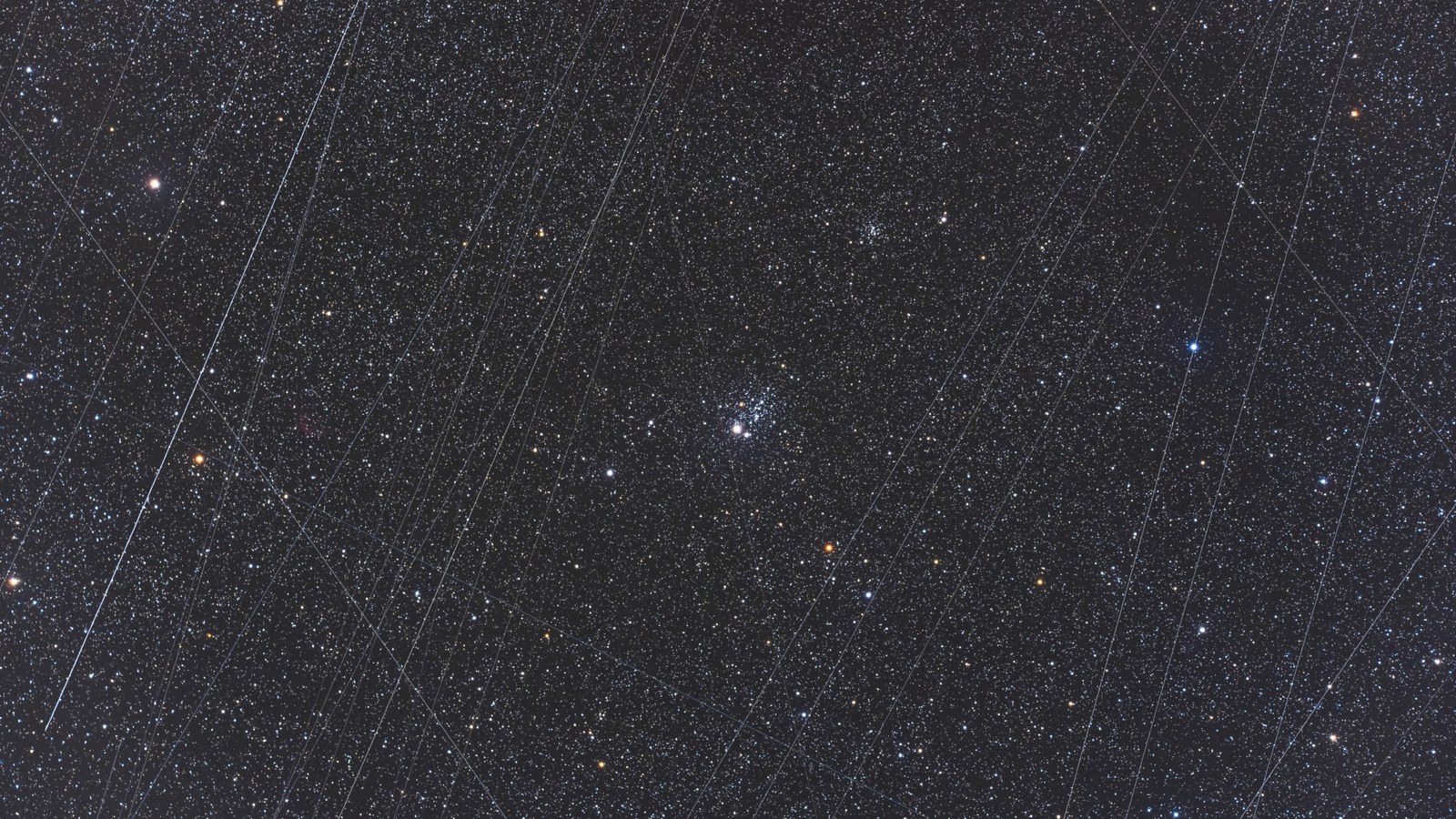 streaks of light crisscross a starry night sky