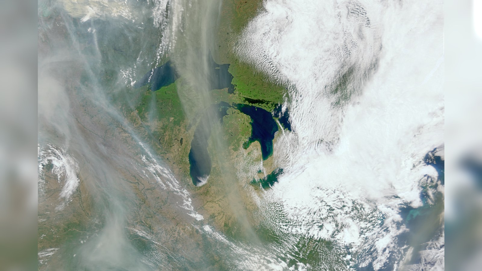 White and gray smoke hovers over an Earth landscape.