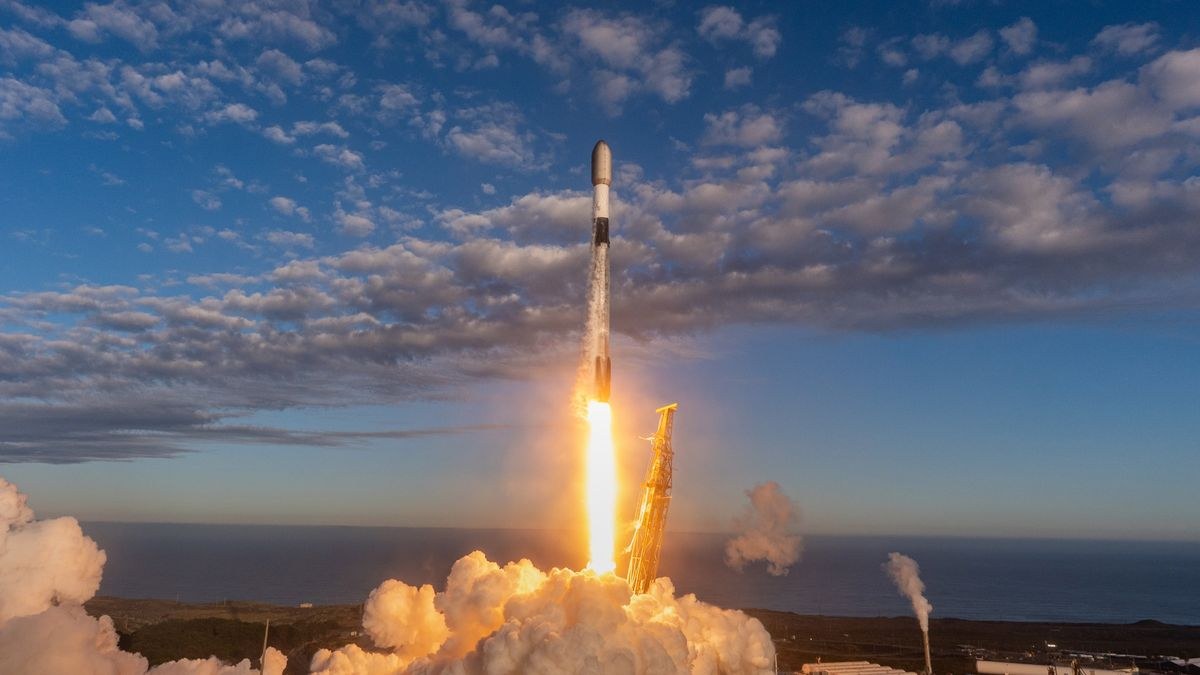 A black and white SpaceX satellite launches Starlink satellites from a seaside launch pad.