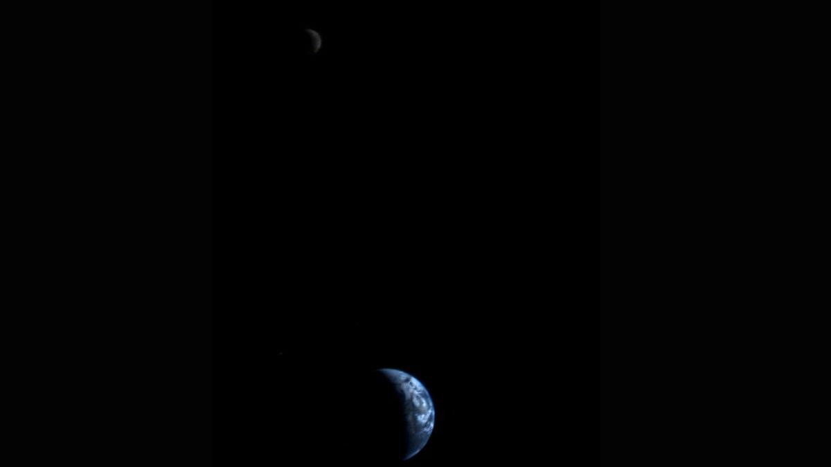 A view of the crescent Earth and moon from deep space.