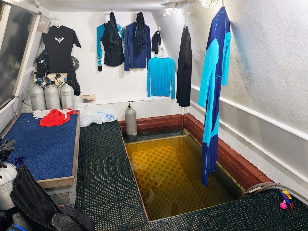 photo inside a small room of a research station, showing wet suits and scuba gear arrayed along the walls
