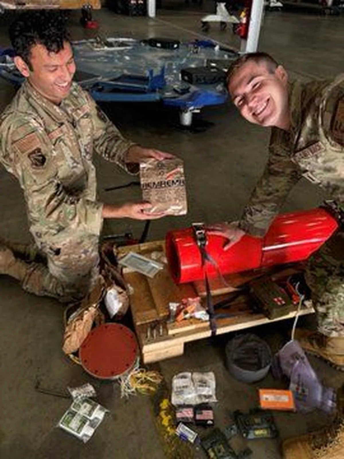 military people smile next to recovered cargo supplies.