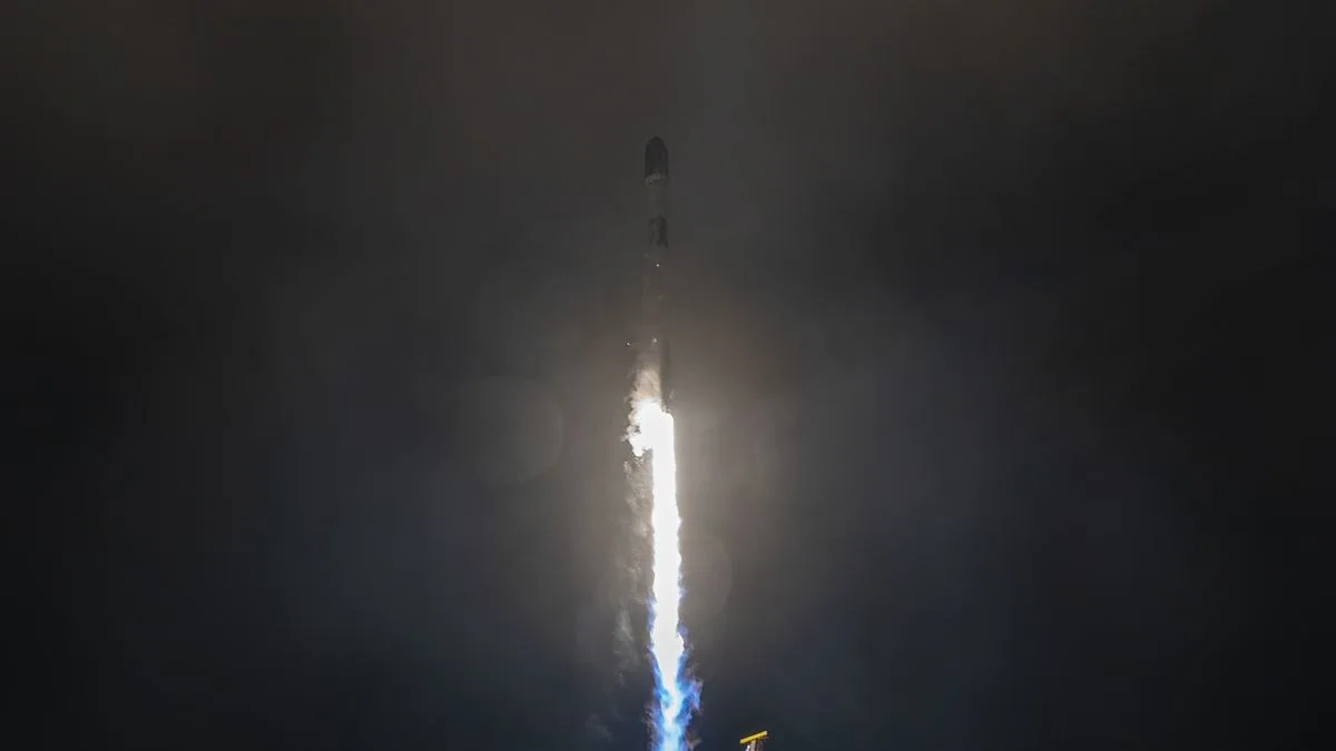 A white rocket blasts off in the dark of night.