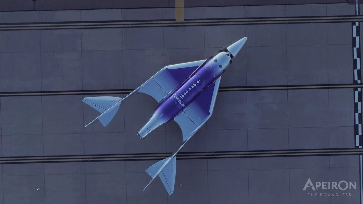 A space plane seen from above sitting on a runway.
